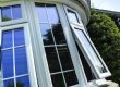 A PVC Bow window with white internal georgian bars